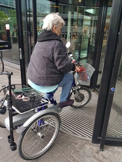 Monique van Stuijvenberg on tricycle at hospital