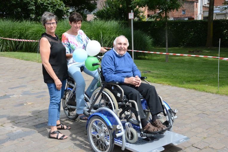 Residents and volunteers residential care facility use a wheelchair bike VeloPlus