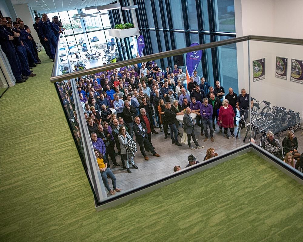 feestelijke opening van raam nieuwe fietsfabriek medewerkers en genodigden