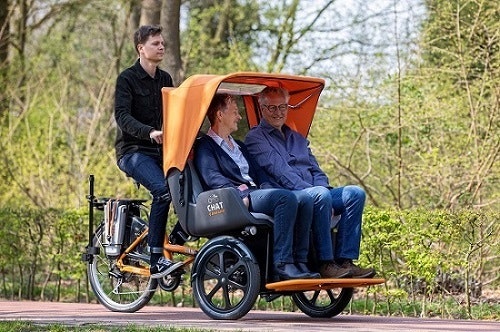 Chat Rickshaw bicycle together with one leg on bicycle Van Raam