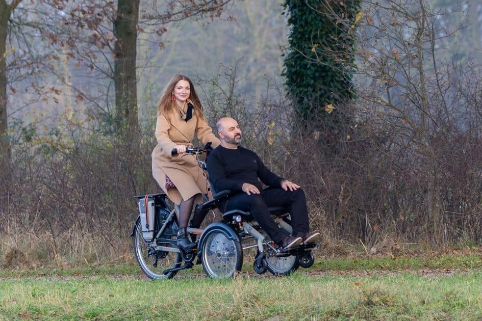 OPair wheelchair bike together with one leg on bicycle Van Raam