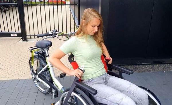 Placer le fauteuil roulant sur le vélo fauteuil roulant Van Raam VeloPlus à l'aide des sangles