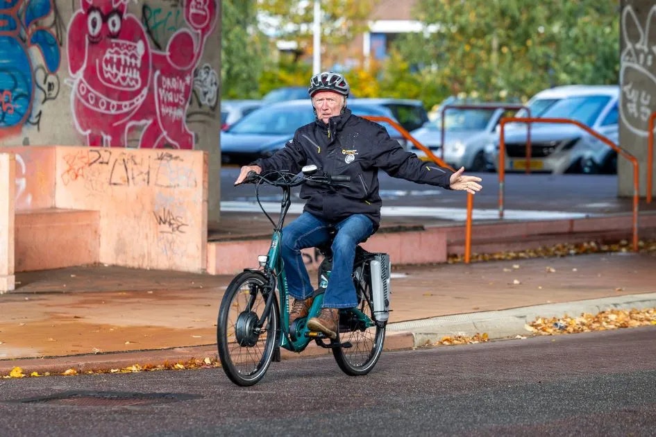 Harry Slinger fietst met helm op balance fiets vanRaam Harry Slinger fietst met helm op balance fiets vanRaam
