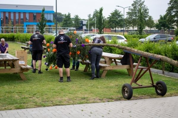 Medewerkers plaatsen meiboom bij nieuwbouw Van Raam